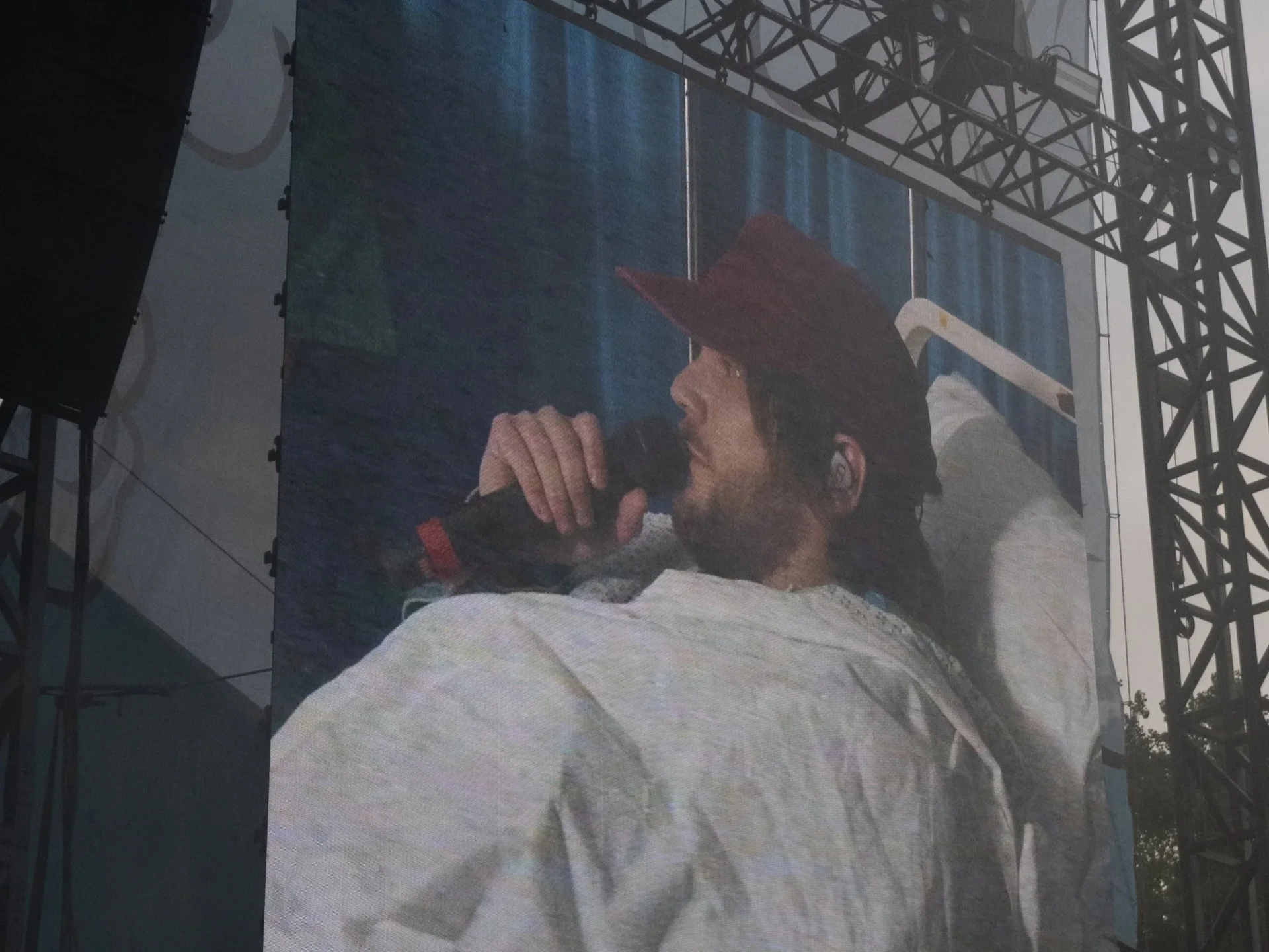 Patrick Stump with a microphone in bed on stage.